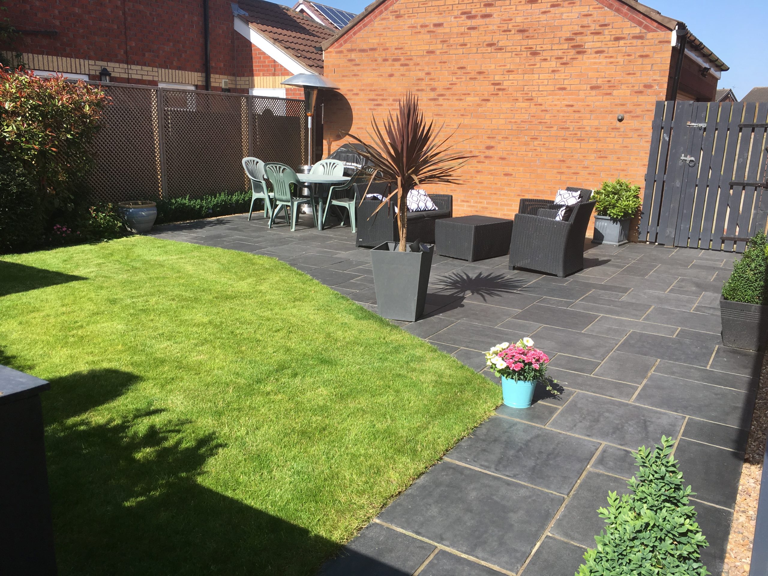 Lawn furniture and garden in front of a single storey extension